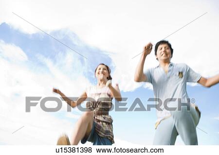 Young Couple Running, Low Angle View View Large Photo Image Stock Photo - Young Couple Running, Low Angle View. Fotosearch