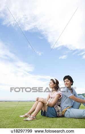 Young Couple Sitting on Grass View Large Photo Image Stock Photo - Young Couple Sitting on Grass. Fotosearch
