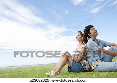 Young Couple Sitting on Grass View Large Photo Image Stock Photography - Young Couple Sitting on Grass. Fotosearch