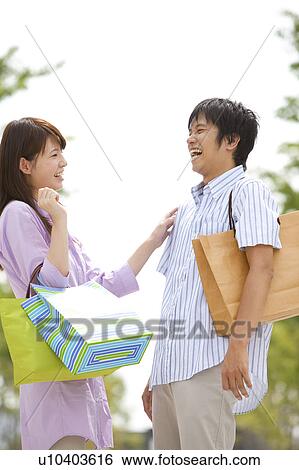 Stock Photograph - Young Couple with Shopping Bags Laughing. Fotosearch
