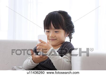 Stock Image - Young Girl Using Mobile Phone. Fotosearch
