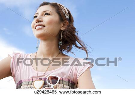 Stock Photography - Young Woman Against Blue Sky. Fotosearch