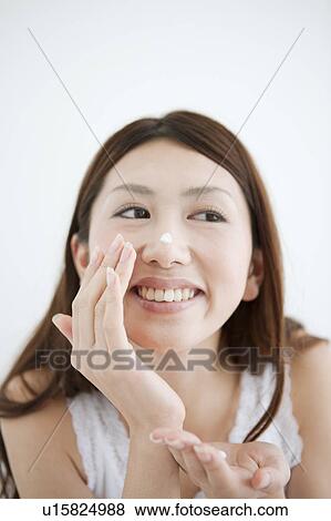 Stock Photo - Young Woman Applying Moisturizer. Fotosearch