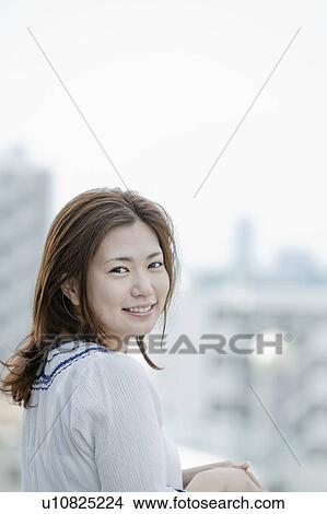 Young woman at balcony looking at camera, Tokyo Prefecture, Honshu, Japan View Large Photo Image Picture - Young woman at balcony looking at camera, Tokyo Prefecture, Honshu, Japan. Fotosearch