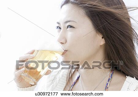 Stock Photo - Young woman drinking a glass of beer, Tokyo Prefecture, Honshu, Japan. Fotosearch