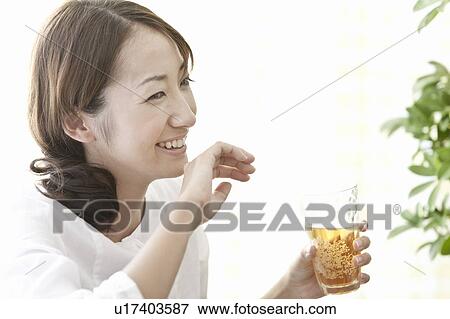Stock Photo - Young woman drinking beer, Tokyo Prefecture, Japan. Fotosearch