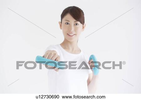 Stock Image - Young Woman Exercising with Dumbbells. Fotosearch