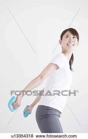 Young Woman Exercising with Dumbbells View Large Photo Image Stock Photo - Young Woman Exercising with Dumbbells. Fotosearch