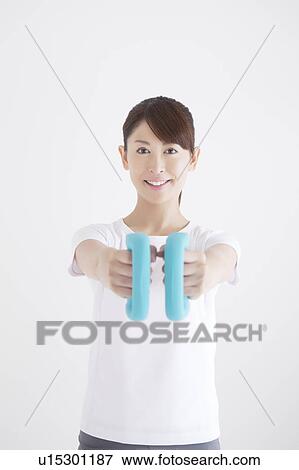 Young Woman Exercising with Dumbbells View Large Photo Image Stock Photo - Young Woman Exercising with Dumbbells. Fotosearch
