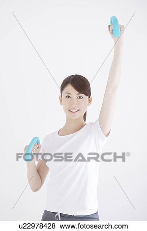 Stock Photo - Young Woman Exercising with Dumbbells. Fotosearch