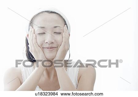 Young woman giving herself a facial massage, Tokyo Prefecture, Japan View Large Photo Image Picture - Young woman giving herself a facial massage, Tokyo Prefecture, Japan. Fotosearch