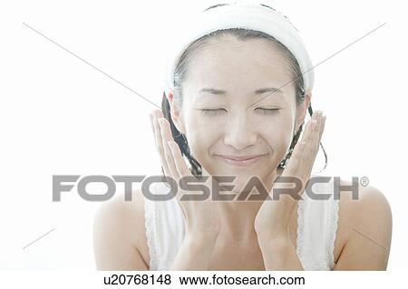 Young woman giving herself a facial massage, Tokyo Prefecture, Japan View Large Photo Image Stock Photo - Young woman giving herself a facial massage, Tokyo Prefecture, Japan. Fotosearch