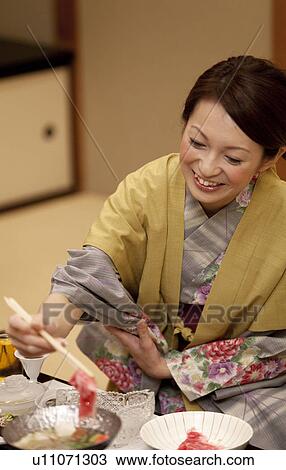 Stock Image - Young Woman Having Dinner. Fotosearch