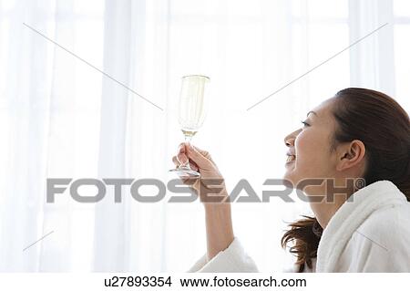 Picture - Young Woman in Dressing Gown Having Champagne. Fotosearch