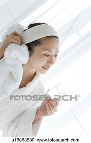 Stock Image - Young Woman in Dressing Gown Having Water. Fotosearch