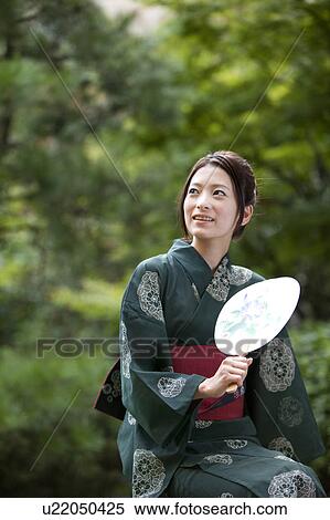 Stock Photography - Young Woman in Yukata Holding Fan. Fotosearch