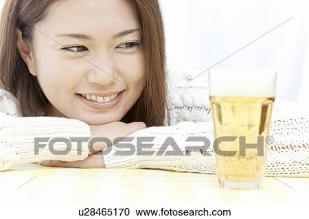 Young woman looking at glass of beer on table, Tokyo Prefecture, Honshu, Japan View Large Photo Image Stock Image - Young woman looking at glass of beer on table, Tokyo Prefecture, Honshu, Japan. Fotosearch