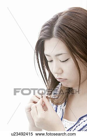 Young woman looking at her hair, Tokyo Prefecture, Honshu, Japan View Large Photo Image Stock Photography - Young woman looking at her hair, Tokyo Prefecture, Honshu, Japan. Fotosearch