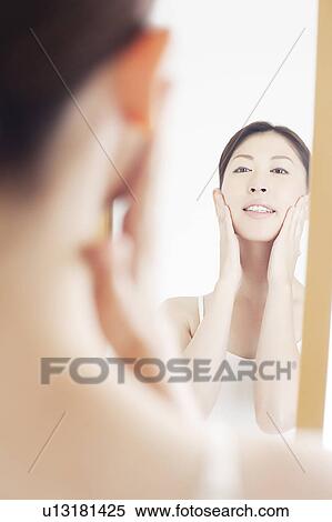 Stock Photography - Young Woman Looking Into Mirror. Fotosearch