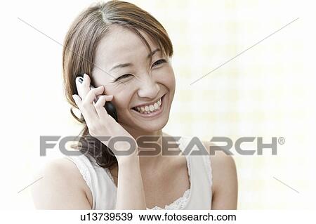Stock Photo - Young woman on a smart phone, Tokyo Prefecture, Japan. Fotosearch