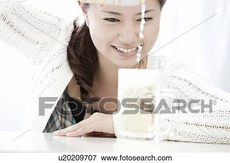 Stock Photo - Young woman pouring highball into glass, Tokyo Prefecture, Honshu, Japan. Fotosearch