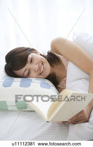 Young Woman Reading Book in Bed View Large Photo Image Stock Image - Young Woman Reading Book in Bed. Fotosearch
