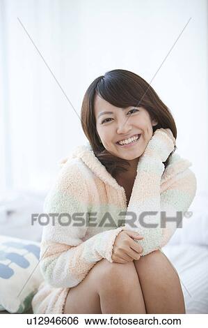 Stock Photograph - Young Woman Sitting on Bed. Fotosearch