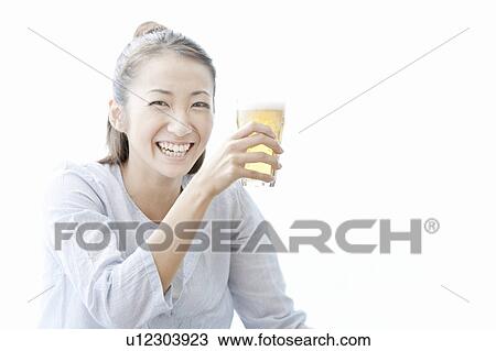 Young woman smiling and holding a glass of beer, Tokyo Prefecture, Japan View Large Photo Image Stock Image - Young woman smiling and holding a glass of beer, Tokyo Prefecture, Japan. Fotosearch