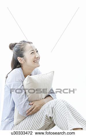 Young woman smiling and holding a cushion, Tokyo Prefecture, Japan View Large Photo Image Stock Image - Young woman smiling and holding a cushion, Tokyo Prefecture, Japan. Fotosearch