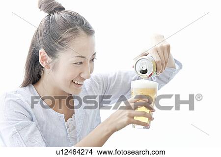 Young woman smiling and pouring beer, Tokyo Prefecture, Japan View Large Photo Image Picture - Young woman smiling and pouring beer, Tokyo Prefecture, Japan. Fotosearch