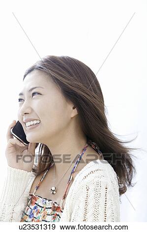Stock Photo - Young woman talking on smart phone, Tokyo Prefecture, Honshu, Japan. Fotosearch