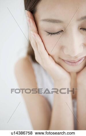 Stock Photo - Young Woman Touching Her Face, High Angle View. Fotosearch
