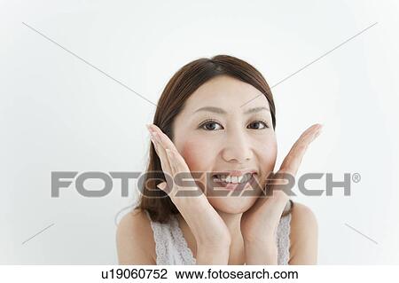 Stock Image - Young Woman Touching Her Face. Fotosearch
