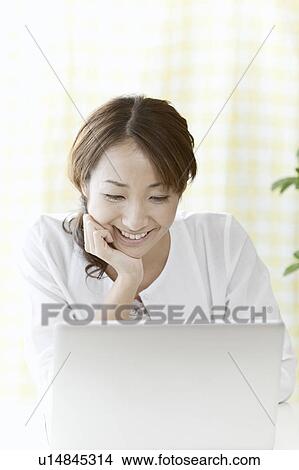 Young woman using a laptop, Tokyo Prefecture, Japan View Large Photo Image Picture - Young woman using a laptop, Tokyo Prefecture, Japan. Fotosearch