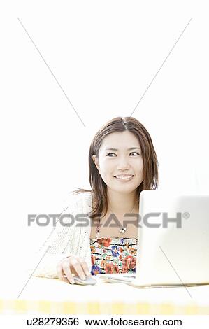 Stock Photograph - Young woman using a laptop, Tokyo Prefecture, Honshu, Japan. Fotosearch