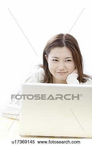 Stock Photography - Young woman using a laptop, Tokyo Prefecture, Honshu, Japan. Fotosearch