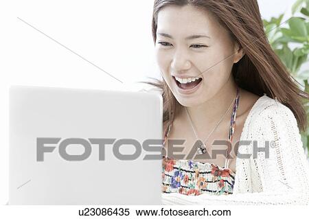 Young woman using a laptop, Tokyo Prefecture, Honshu, Japan View Large Photo Image Stock Photography - Young woman using a laptop, Tokyo Prefecture, Honshu, Japan. Fotosearch