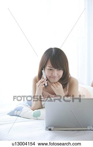 Young Woman Using Mobile Phone and Laptop View Large Photo Image Picture - Young Woman Using Mobile Phone and Laptop. Fotosearch