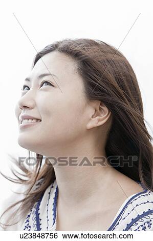 Stock Photograph - Young woman with hair blowing in the wind, Tokyo Prefecture, Honshu, Japan. Fotosearch