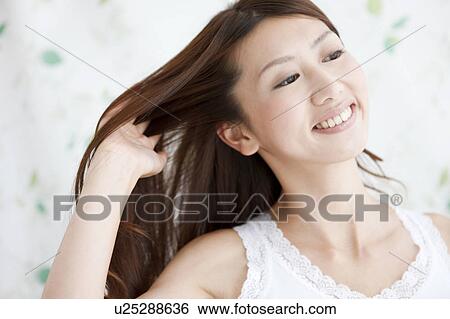 Stock Photograph - Young Woman with Hand in Hair. Fotosearch
