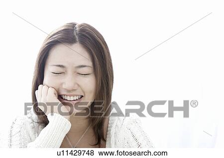 Stock Photo - Young woman with hand on chin, Tokyo Prefecture, Honshu, Japan. Fotosearch