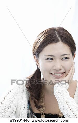 Stock Photograph - Young woman with hand on chin, Tokyo Prefecture, Honshu, Japan. Fotosearch