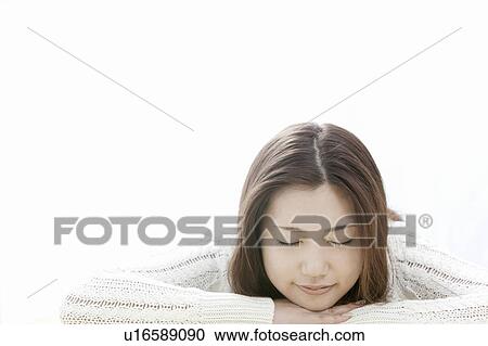 Stock Image - Young woman with head in hands, Tokyo Prefecture, Honshu, Japan. Fotosearch