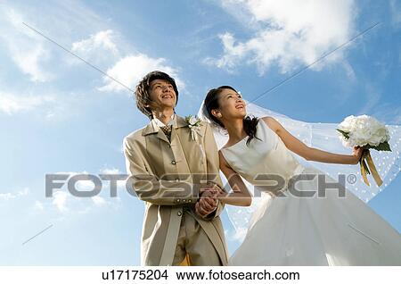 Picture - Bride and bridegroom holding hands. Fotosearch