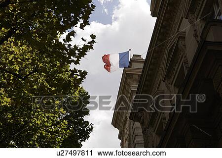Stock Image - Building in Paris and French flag, Paris, France. Fotosearch