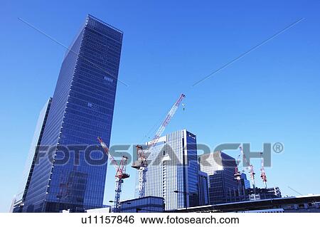 Stock Photograph - Building under construction and crane, Chiyoda Ward, Tokyo Prefecture, Honshu, Japan. Fotosearch