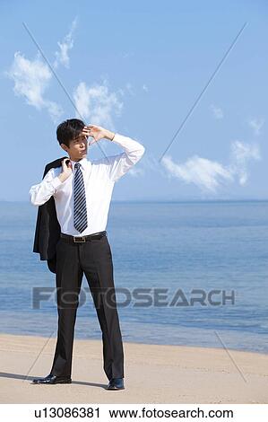 Stock Image - Businessman hiding eyes from the sunlight. Fotosearch