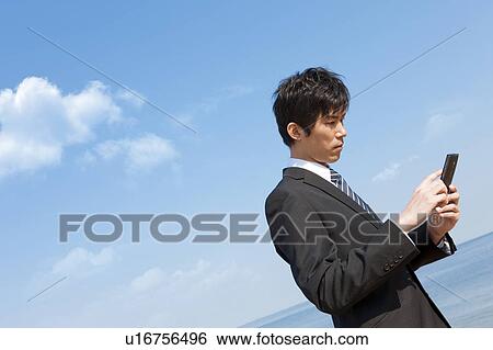 Stock Photograph - Businessman holding a cell phone. Fotosearch