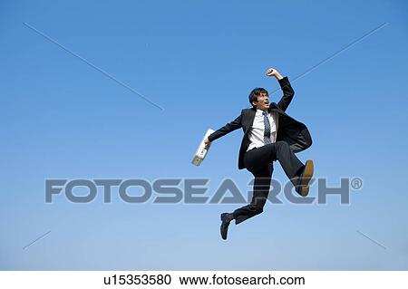 Stock Image - Businessman jumping with briefcase. Fotosearch