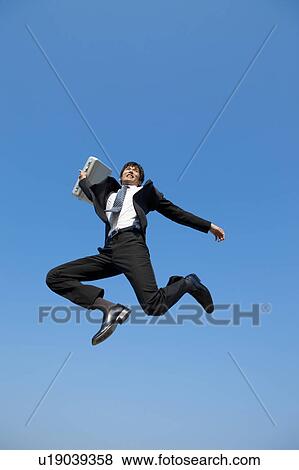 Stock Photo - Businessman jumping with briefcase. Fotosearch